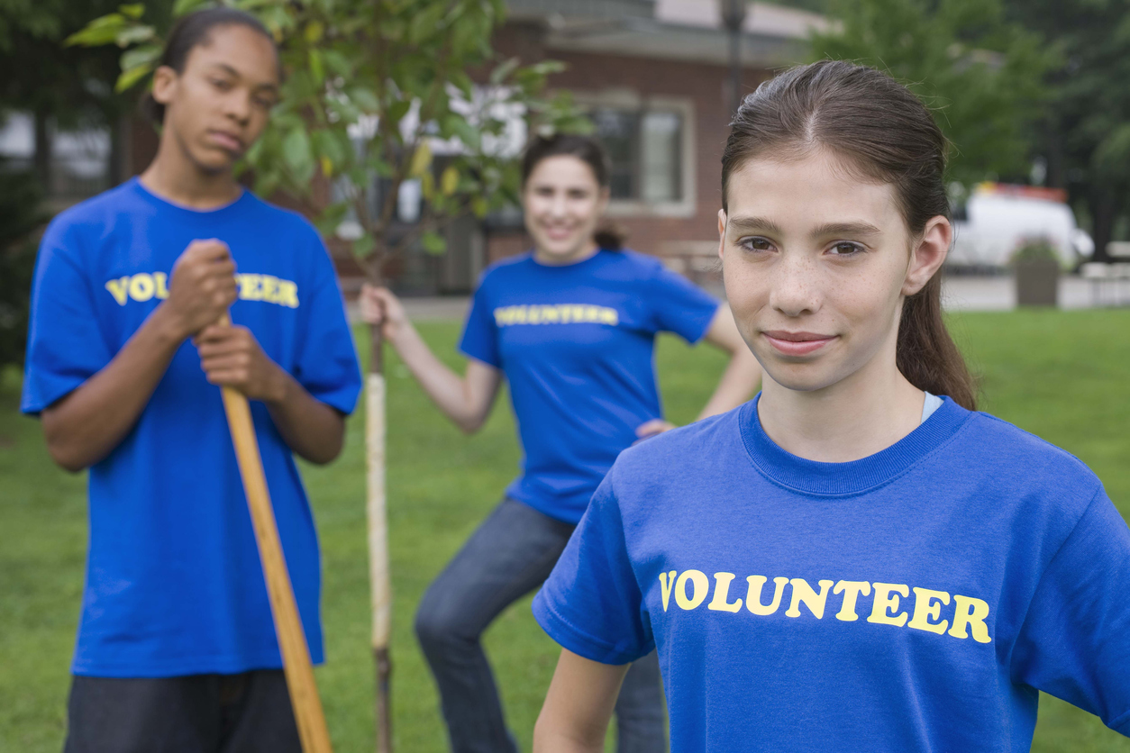 Volunteers holding gardening tools